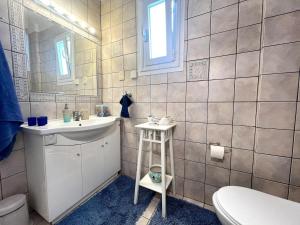 ein Badezimmer mit Waschbecken, Toilette und Spiegel in der Unterkunft Sea View Family Beach House in Aghia Marina + 18 Fotos