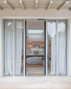 a bedroom with a bed through a sliding glass door at Suite Cosy Barbizon in Barbizon