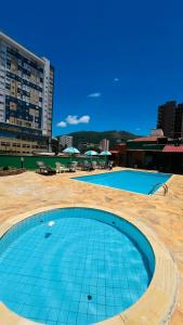 an empty swimming pool in a city with buildings at Hotel Lux in Poços de Caldas
