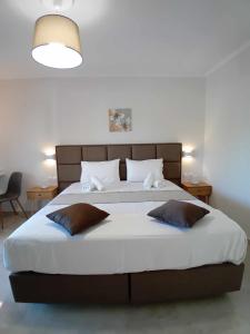 Un dormitorio con una cama grande con dos almohadas. en Roussa's Apartments, en Laganas