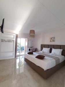 1 dormitorio grande con 1 cama grande y cocina en Roussa's Apartments, en Laganas