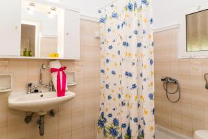 Un baño con lavabo y cortina de ducha. en Roussa's Apartments, en Laganas