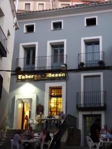 personas sentadas en mesas fuera de un edificio en Casa de Tintas, en Cuenca