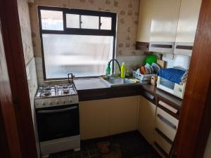a small kitchen with a stove and a sink at A pasos de la playa in Algarrobo