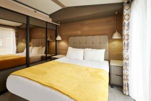 a bedroom with two beds and a yellow blanket at Royal Pines Lodge with Hot tub in Allerthorpe