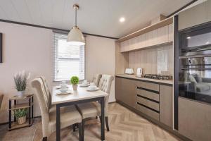 a kitchen and dining room with a table and chairs at Royal Pines Lodge with Hot tub in Allerthorpe