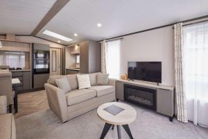 a living room with a couch and a fireplace at Royal Pines Lodge with Hot tub in Allerthorpe