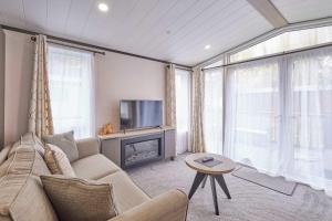 a living room with a couch and a fireplace at Royal Pines Lodge with Hot tub in Allerthorpe