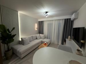 a white living room with a couch and a table at Nexa Suite in Komotini