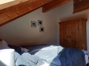 Un dormitorio con una cama y un armario de madera. en Ferienwohnung An der Kapf, en Münsingen