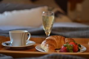 una mesa con un plato de pan y una taza de champán en Ferienwohnung An der Kapf, en Münsingen