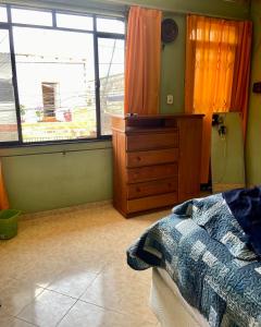 a bedroom with a bed and a dresser and a window at Cantinho Perfeito in Belém