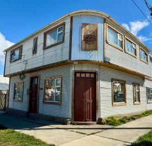 a large white house with a brown door at Magellanic House in Puerto Natales