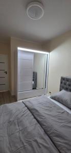 a bedroom with a large bed with a large window at Apartament Srebrny Quick Park Oława in Oława