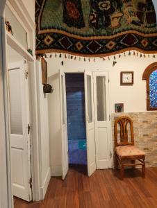 une pièce avec un tapis au plafond et une chaise dans l'établissement Artistic Flat by Luxor Temple & Ancient Souq, à Louxor