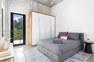 Un dormitorio con una cama grande y una ventana. en Villa Retro Mirage, en Biscayne Park 31 fotos más
