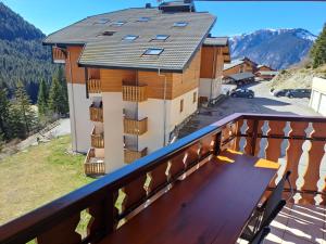 een balkon van een gebouw met daarop een houten bank bij Duplex au Col du Corbier in Le Biot