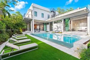 Una vista exterior de una casa con piscina. en Villa Retro Mirage, en Biscayne Park