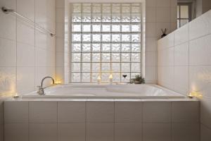 a white bathroom with a tub and a window at Bedford Beauty Stylish Retro Family Home with office in Marion +23 photos