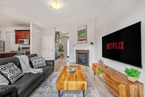 a living room with a couch and a tv on a wall at Single 3 Bedroom Full Private House in Airdrie