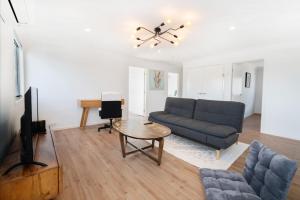 ein Wohnzimmer mit einem blauen Sofa und einem Tisch in der Unterkunft Spacious Retreat with Balcony Patio and Family Comfort in Doolandella