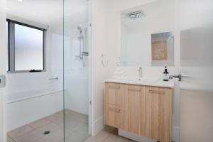 ein weißes Badezimmer mit Waschbecken und Dusche in der Unterkunft Spacious Retreat with Balcony Patio and Family Comfort in Doolandella + 21 Fotos