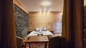 una habitación de hotel con una cama y una mesa en The clifftonn stays, en Jibhi