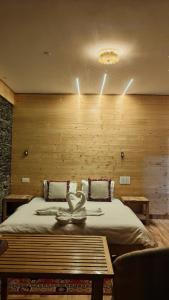 Un dormitorio con una cama grande con una pared de madera. en The clifftonn stays, en Jibhi 35 fotos más