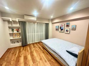 a bedroom with a white bed and a wooden floor at Aa歌舞伎町 东京最中心 东新宿四分钟 in Wada