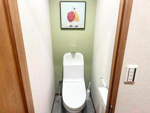 a bathroom with a toilet with a picture on the wall at Aa歌舞伎町 东京最中心 东新宿四分钟 in Wada +3 photos