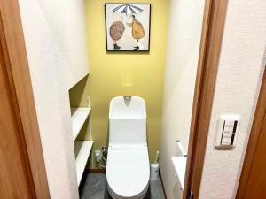 a small bathroom with a toilet with a picture on the wall at Aa歌舞伎町 东京最中心 东新宿四分钟 in Wada