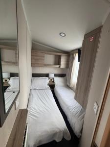 a small room with two beds in it at Luxury Seafront 3 Bedroom Caravan in Minishant