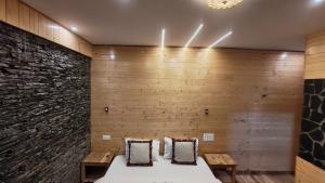 una cama en una habitación con una pared de ladrillo en The clifftonn stays, en Jibhi