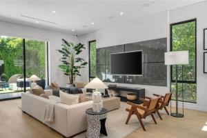 a living room with a couch and a tv at Luxury Escape 6BR Villa Pool, Gym, Theatre, EV in Sherman Oaks