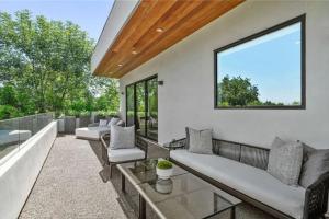 a patio with couches and tables and a window at Luxury Escape 6BR Villa Pool, Gym, Theatre, EV in Sherman Oaks