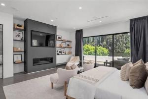 a bedroom with a white bed and a large window at Luxury Escape 6BR Villa Pool, Gym, Theatre, EV in Sherman Oaks +48 photos
