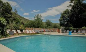 a swimming pool with chairs and a bunch at Oh! Campings - Medrose Camping Ardèche in Saint-Thomé