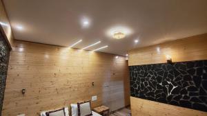 un baño con paredes revestidas de madera y toallas en The clifftonn stays, en Jibhi