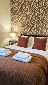 a bedroom with a large bed with two towels on it at The Nook in Huddersfield