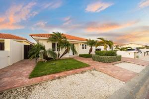 ein Haus mit Palmen und einem Innenhof in der Unterkunft Coastal Paradise in Tanki Lender