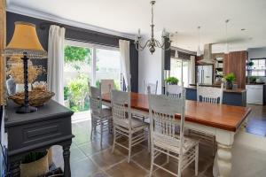 Lagoonside Family Haven في كنيسنا: مطبخ وغرفة طعام مع طاولة وكراسي خشبية