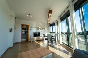 een woonkamer met een tafel, stoelen en ramen bij Apartamento familiar en Torreblanca con vistas al mar, aire acondicionado y cerca de la playa in Torreblanca