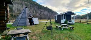 a small hut with a picnic table and a picnic bench at Liten gårdshytte til leie in Åseral