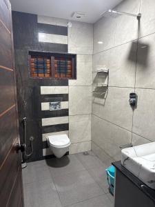 ein Badezimmer mit Toilette, Waschbecken und Dusche in der Unterkunft Grace Home in Ūdumbanshola