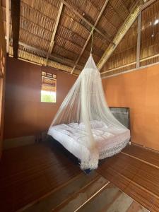 a bed in a room with a mosquito net at The Driftwood House 