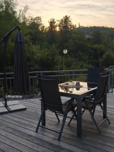 two chairs and a table and an umbrella on a deck at Am Quellenhäuschen in Naila