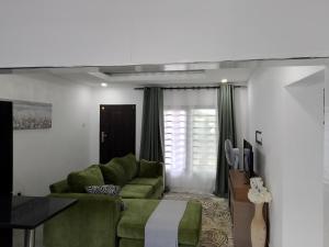 een woonkamer met een groene bank en een tafel bij T & M Apartments in Ndola