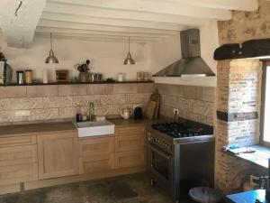 a kitchen with a stove and a sink at Lapeyrouse Bonnet in Montmirail
