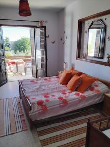 Un dormitorio con una cama con almohadas naranjas y una ventana. en Résidence Kyranis appartement Gyptis, en Sfax