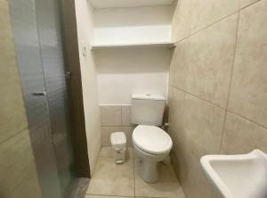 a small bathroom with a toilet and a sink at kitnet no centro histórico in São João del Rei